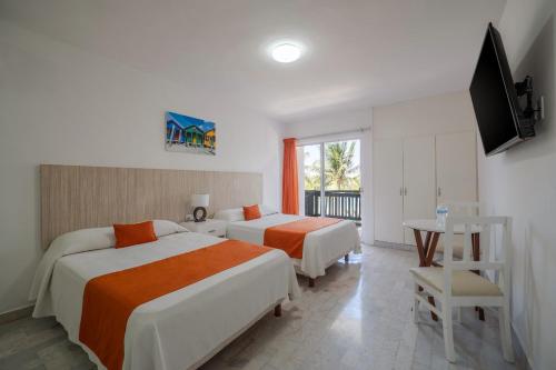 a hotel room with two beds and a television at Hotel Imperial Laguna Faranda Cancún in Cancún