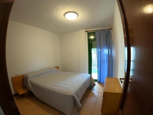 ein Schlafzimmer mit einem Bett und eine Tür mit einem Fenster in der Unterkunft apartamento con jardin privado cerca de la playa! in Amposta