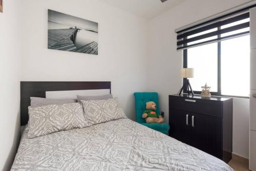 a bedroom with a bed and a blue chair at New Ampartment For Rent in Jarretadera