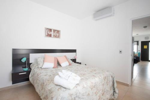 a bedroom with a large bed with pink and white pillows at New Ampartment For Rent in Jarretadera