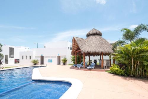 a resort with a swimming pool and a thatch roof at New Ampartment For Rent in Jarretadera