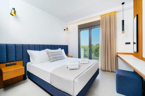 a bedroom with a bed and a large window at Olia Thassos - Luxury Apartments in Limenas