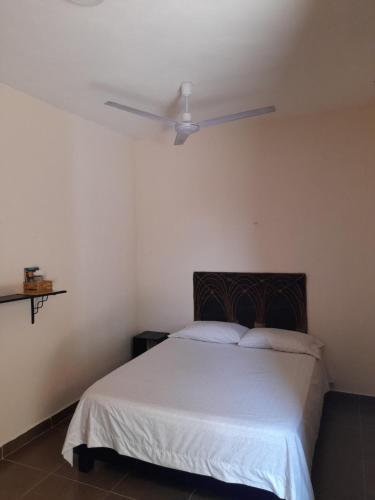 a bedroom with a bed with a ceiling fan at Villa lirios in Valladolid