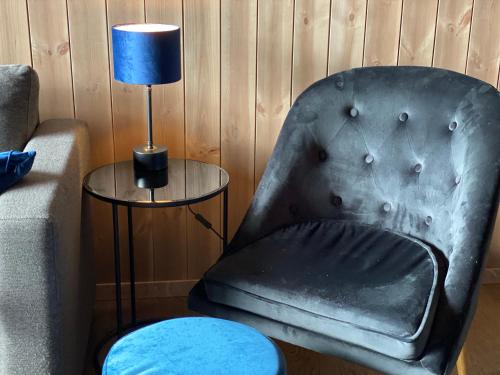a leather chair next to a table with a lamp at New apartment, Gausta in Rjukan. Ski in/ ski out in Rjukan