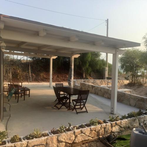 a patio with a table and chairs under a pavilion at New Rooms on The Beach in Pozzallo