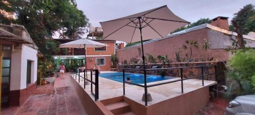 a house with a swimming pool and an umbrella at Charaí Lodge in Puerto Iguazú