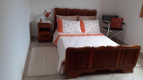 1 dormitorio con 1 cama grande de madera con almohadas de color naranja en Peaceful 2-Bed Villa in Assafarge Coimbra, 