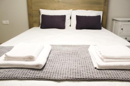 a bed with white blankets and pillows on it at SIBL LOFTS in Thessaloniki