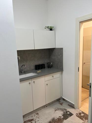 a kitchen with white cabinets and a sink at שחף ברוזמרין in Eilat