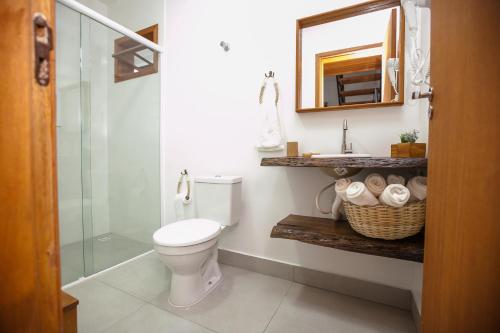 uma casa de banho com um WC, um chuveiro e um espelho. em RECANTO NOVÍSSIMO em BC na Praia do Estaleiro no Balneário Camboriú