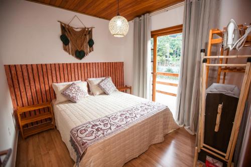 um quarto com uma cama num quarto com uma janela em RECANTO NOVÍSSIMO em BC na Praia do Estaleiro no Balneário Camboriú