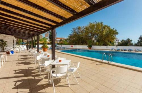 un patio con mesas y sillas junto a una piscina en Endless Summer, en Albufeira