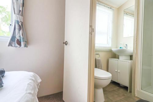 a bathroom with a toilet and a sink at Fabulous Modern Holiday Home BEACH Cleethorpes Beach Thorpe Park Haven in Cleethorpes