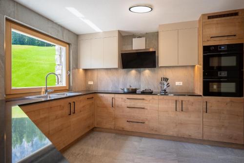 a kitchen with wooden cabinets and a large window at Chalet Fisti in La Villa