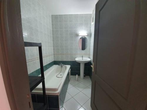 een badkamer met een bad en een wastafel bij Escale sudisteAppartement T2*** in Saint-Louis