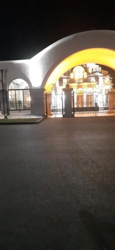 a large building with a large archway at night at Boutique hotel in Poti