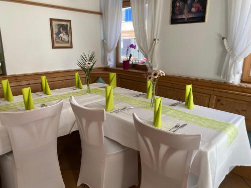 a dining room with a table and chairs with yellow napkins at Gasthof/Pizzeria Hirsch in Mühlheim an der Donau