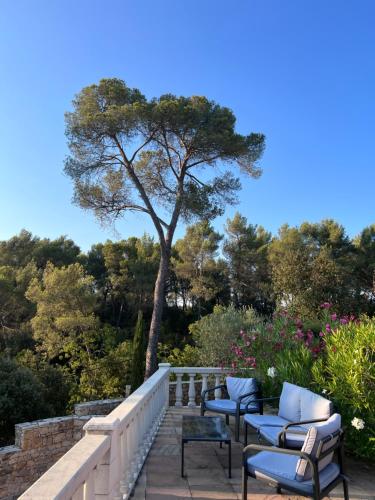 eine Terrasse mit Stühlen und einem Baum im Hintergrund in der Unterkunft La Farigoule in Aix-en-Provence