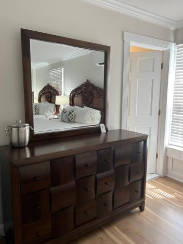 a large mirror on top of a dresser in a bedroom at Elaine's Cape May Boutique Hotel in Cape May