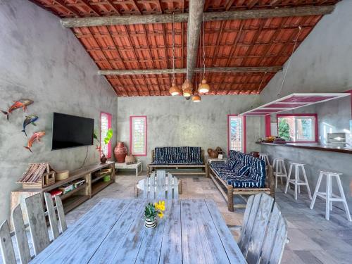 Casa Zulu Umoya في إيكاري: غرفة معيشة مع طاولة وكراسي خشبية