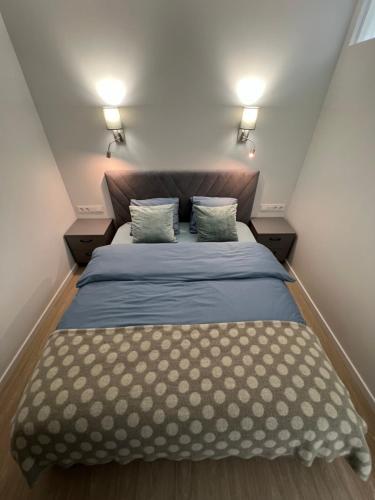 ein kleines Schlafzimmer mit einem Bett und zwei Kissen in der Unterkunft Bell Tower Apartment in Plungė