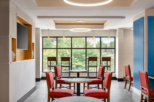 a dining room with tables and chairs and a large window at Holiday Inn Express & Suites Greenville-Downtown by IHG in Greenville