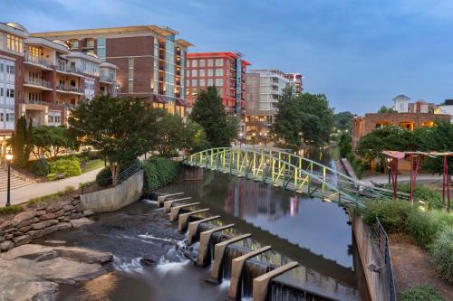 a bridge over a river in a city with buildings at Holiday Inn Express & Suites Greenville-Downtown by IHG in Greenville