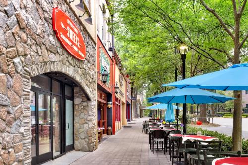 an empty street with tables and umbrellas outside a building at Holiday Inn Express & Suites Greenville-Downtown by IHG in Greenville