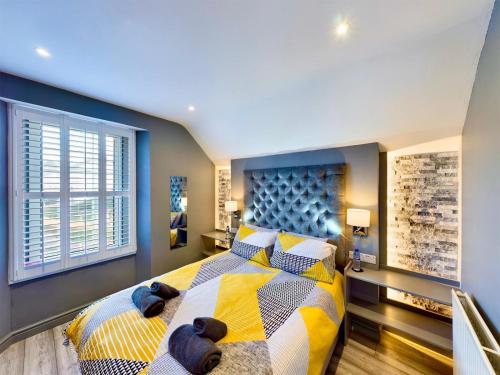 a bedroom with a large bed with yellow and blue at Glan Aber 1890, snowdonia, Llanrwst in Llanrwst