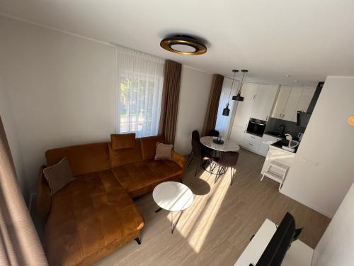 un soggiorno con divano e tavolo di Bell Tower Apartment a Plungė