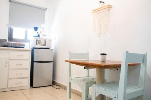 a kitchen with a table and two chairs and a refrigerator at Isla Venados Renta Vacacional in Mazatlán