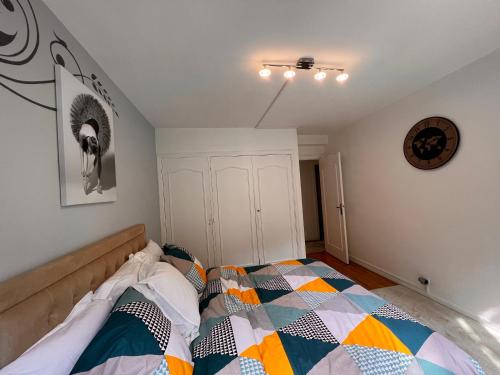 une chambre avec un lit avec une couette colorée dans l'établissement Appartement Paris Grenelle - HALA PARIS, à Paris