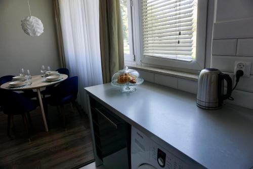 a kitchen with a table and a bowl on the counter at Mały Kwadrat Tychy in Tychy