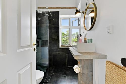 a bathroom with a sink and a mirror at Sunny 1st floor apartment in Tisvildeleje