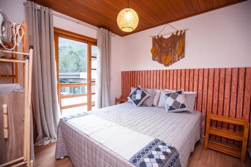 a bedroom with a large bed and a balcony at Casa em Balneário Camboriú na Praia do Estaleiro in Balneário Camboriú