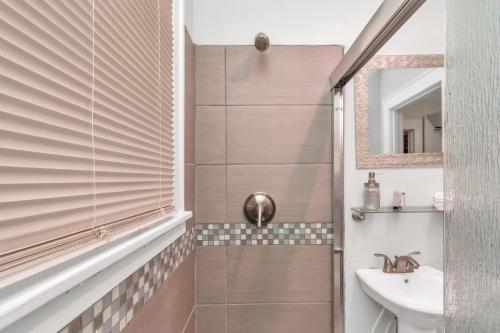 uma casa de banho com um chuveiro, um lavatório e um espelho. em Calm Cozy Oasis in the Heart of Houston by Toyota Center em Houston