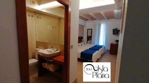 uma casa de banho com uma cama, um lavatório e um espelho. em HOTEL ISLA PLANA em Tabarca