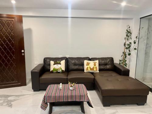 a living room with a brown couch and a coffee table at Slaviero Home II, Cuzco, Perú in Cusco