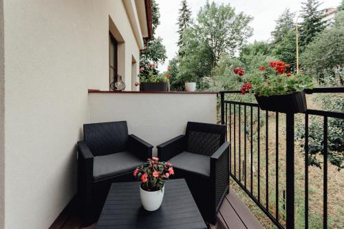 a pair of chairs on a balcony with flowers at Apartmán vo vile Kammergraf in Banská Štiavnica