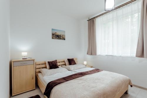 a bedroom with a large bed and a window at Apartmán vo vile Kammergraf in Banská Štiavnica