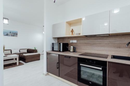 a kitchen with a stove top oven next to a living room at Apartmán vo vile Kammergraf in Banská Štiavnica