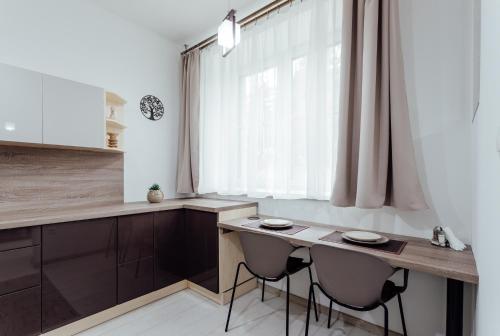 a kitchen with a table and two chairs and a window at Apartmán vo vile Kammergraf in Banská Štiavnica