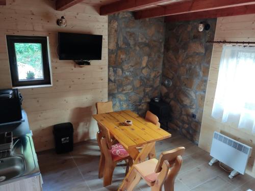 ein Esszimmer mit einem Holztisch und Stühlen in der Unterkunft Lodge Sisters in Sekulić 