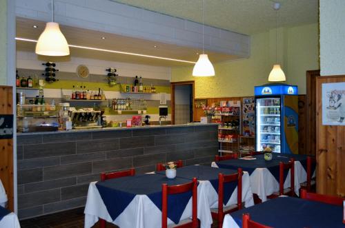 カンポドルチーノにあるCampodolcino Campingのテーブル2台とカウンター付きのレストラン