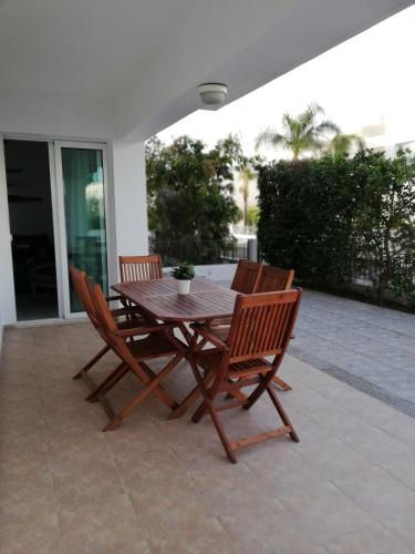 a wooden table and chairs on a patio at Yiasemi Ground floor Holiday Appartment in Paralimni