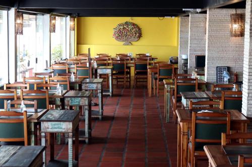 an empty restaurant with wooden tables and chairs at Delphin Beach Hotel in Guarujá