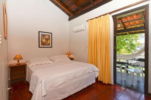 1 dormitorio con cama y ventana grande en Bahia do Sonho, en Bombinhas
