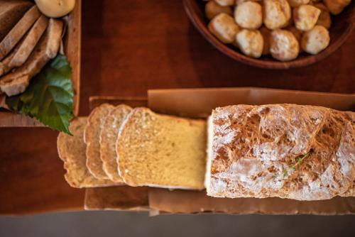 a loaf of bread on a table next to a bowl of breadsticks at Pousada Morena in Fernando de Noronha