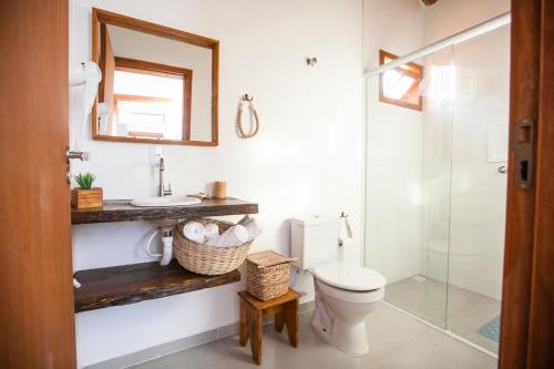 a bathroom with a toilet and a sink and a mirror at CURTA O VERÃO DE BC COM ESTILO! Casa no Estaleiro in Balneário Camboriú