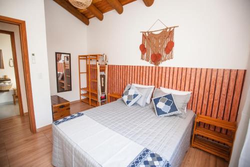 Schlafzimmer mit einem Bett mit blauen und weißen Kissen in der Unterkunft CURTA O VERÃO DE BC COM ESTILO! Casa no Estaleiro in Balneário Camboriú